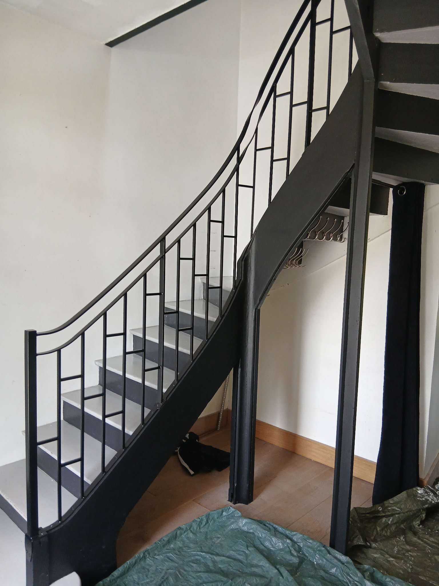 Vue d'ensemble de l'escalier tournant hélicoïdal avec garde-corps acier noir, maison haussmannienne